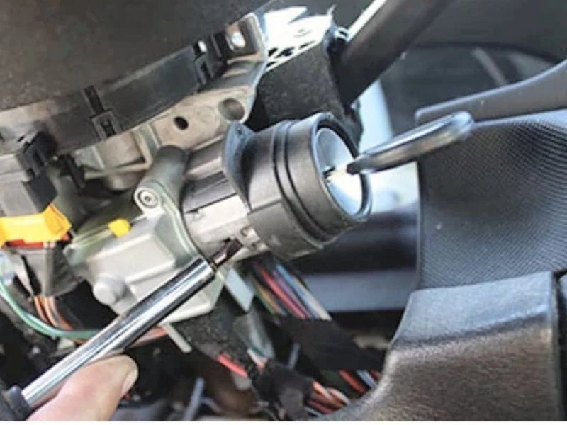 Ignition lock cylinder being removed from a steering column